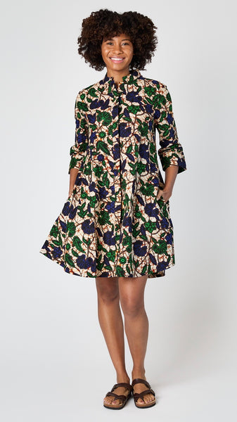 Model wearing Zuri dress in "Larkspur" print with brown leather sandals.