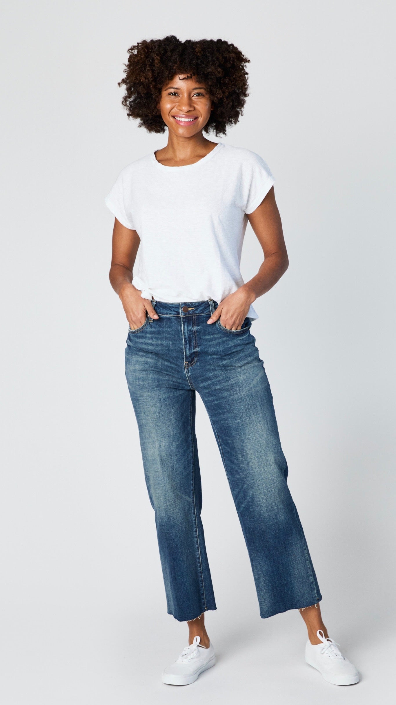 Model wearing white cropped sleeve boxy top with dark vintage wash cropped wideleg jeans and white sneakers.