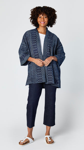 Model wearing indigo block print cotton kimono, white t-shirt, cropped wide leg dark wash jean, and white sandals.