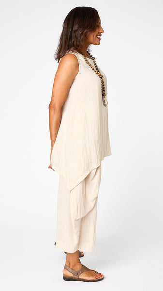 Model wearing cloud long tunic tank with sweeping swing hemline, cloud double pocket pants, and brown sandals.
