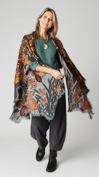 Model wearing gray and orange floral ruana over myrtle bias cut top and iron cropped dart pants with black leather boots.