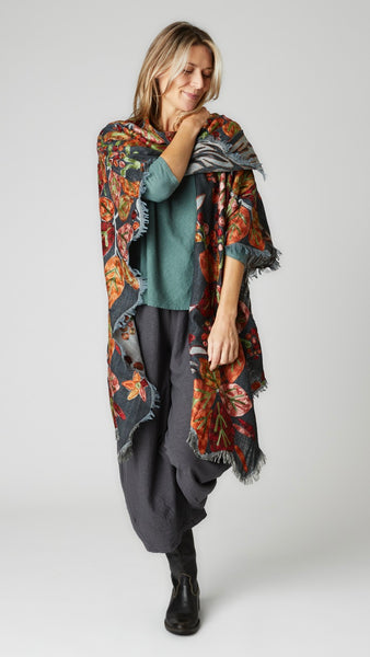Model wearing gray and orange floral ruana over myrtle bias cut top and iron cropped dart pants with black leather boots.