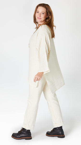 Model wearing natural/cream 3/4 sleeve, split hem, flowy high-low tunic in double cotton, with ecru straight leg jeans, and black lace-up leather boots.
