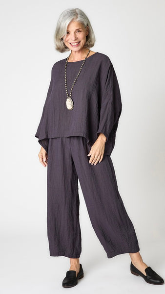 Model wearing anthracite cropped one size top in travel weight rayon with anthracite cropped pants with ankle darts and black leather loafers.