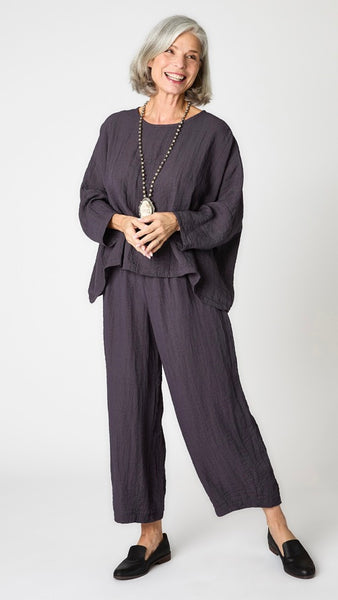 Model wearing anthracite cropped one size top in travel weight rayon with anthracite cropped pants with ankle darts and black leather loafers.