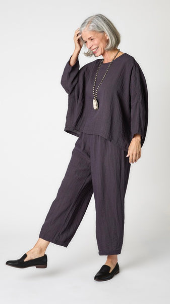 Model wearing anthracite cropped one size top in travel weight rayon with anthracite cropped pants with ankle darts and black leather loafers.