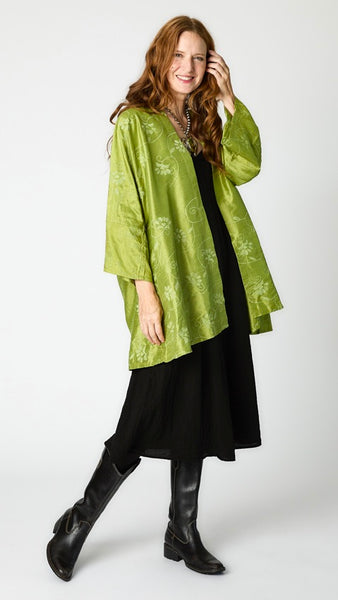 Model wearing citron silk embroidered kimono-style jacket over black rayon romper, black tights, and black leather boots.