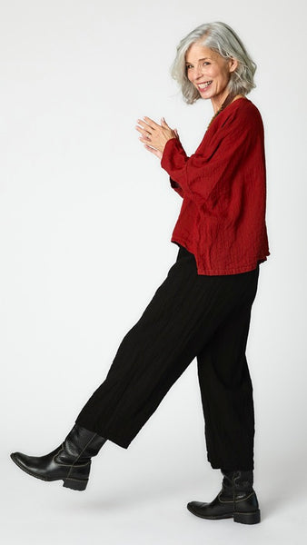 Model wearing black cropped one size top in travel weight rayon with black cropped pants with ankle darts and black leather boots.