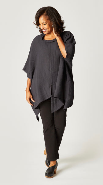 Model wearing black pearl loose cowl neck tunic with asymmetrical hem and 3/4 sleeves, and black straight leg jeans.