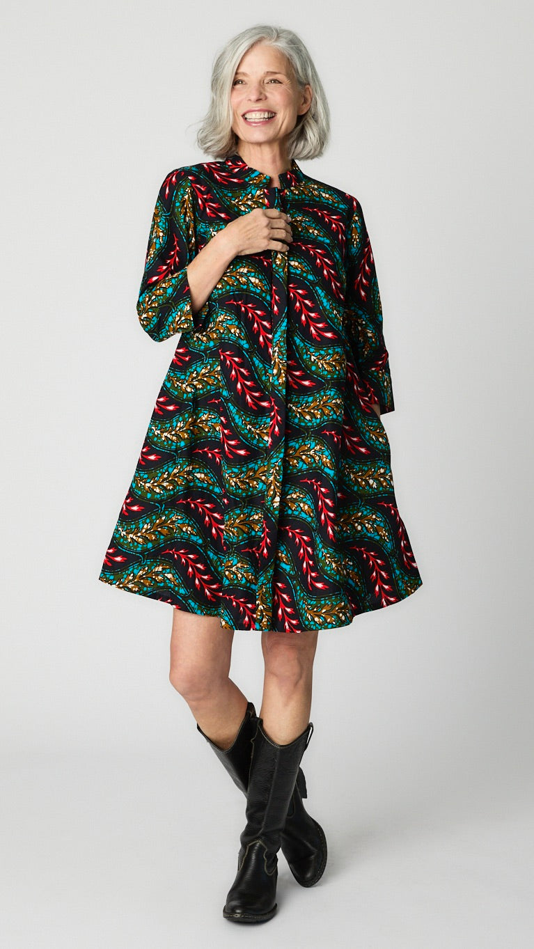 Model posing in "Light as a Feather" Zuri dress with tall black leather boots.