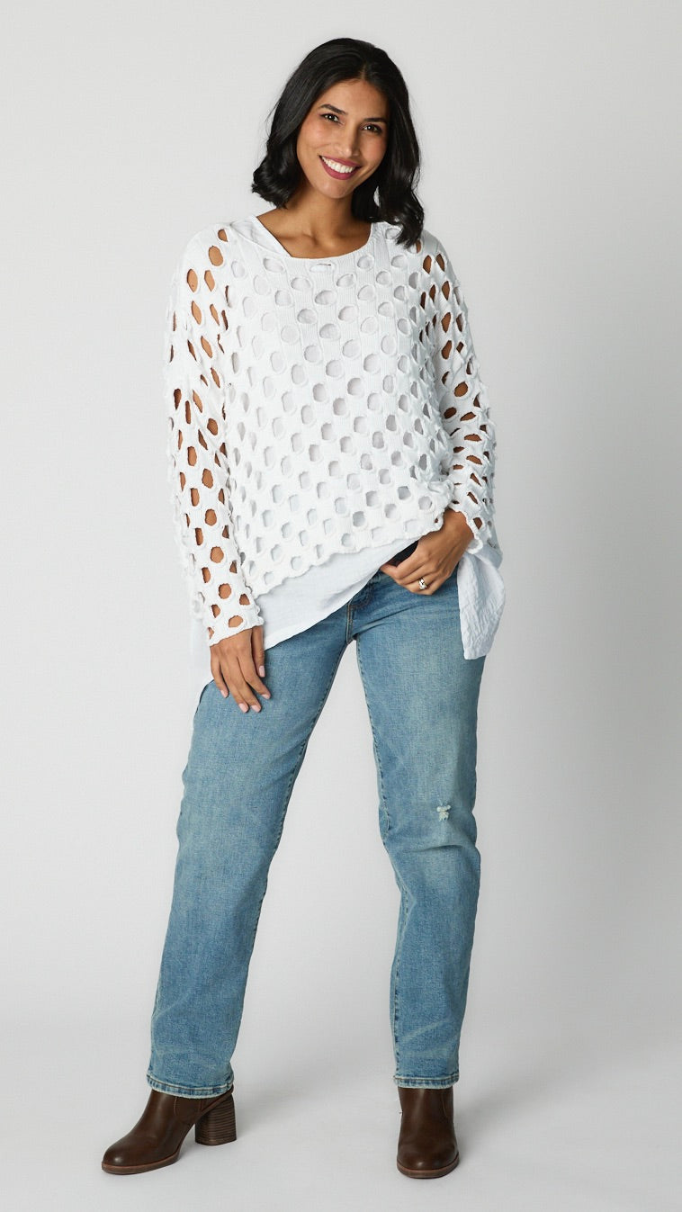 Model wearing white cotton handknit sweater overlay, white rayon tunic tank, and straight leg light wash jeans with brown leather stack heels.