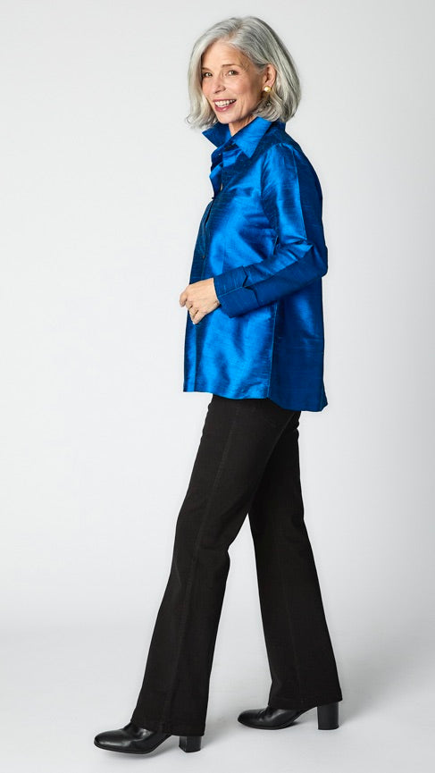 Model wearing royal raw silk button-up blouse with black horn buttons and 3/4 sleeves, black wideleg trousers, and black leather heeled boot.