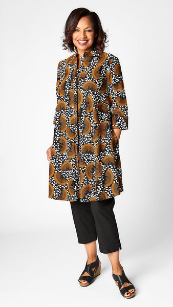 Model wearing “Slice of Life” print Zuri dress with black tapered cropped pant in poplin, and black leather wedge sandals.
