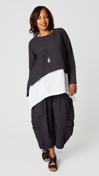 Model wearing black pearl long sleeve cropped top with A-line silhouette, chalk long tank, black pearl double pocket pant, and beetle pendant necklace.
