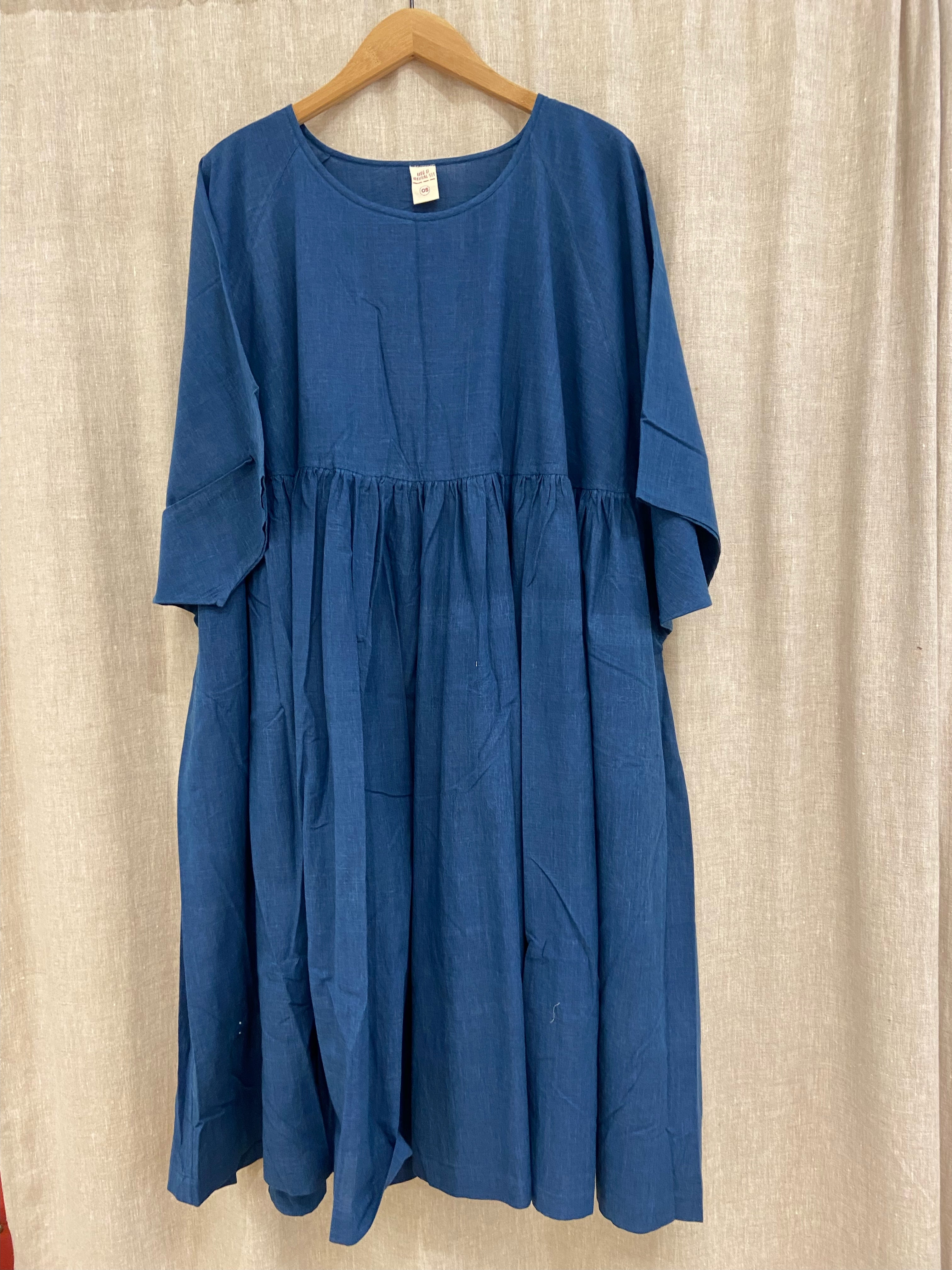 Oversized indigo cotton dress with raglan sleeves and waist-gathered skirt