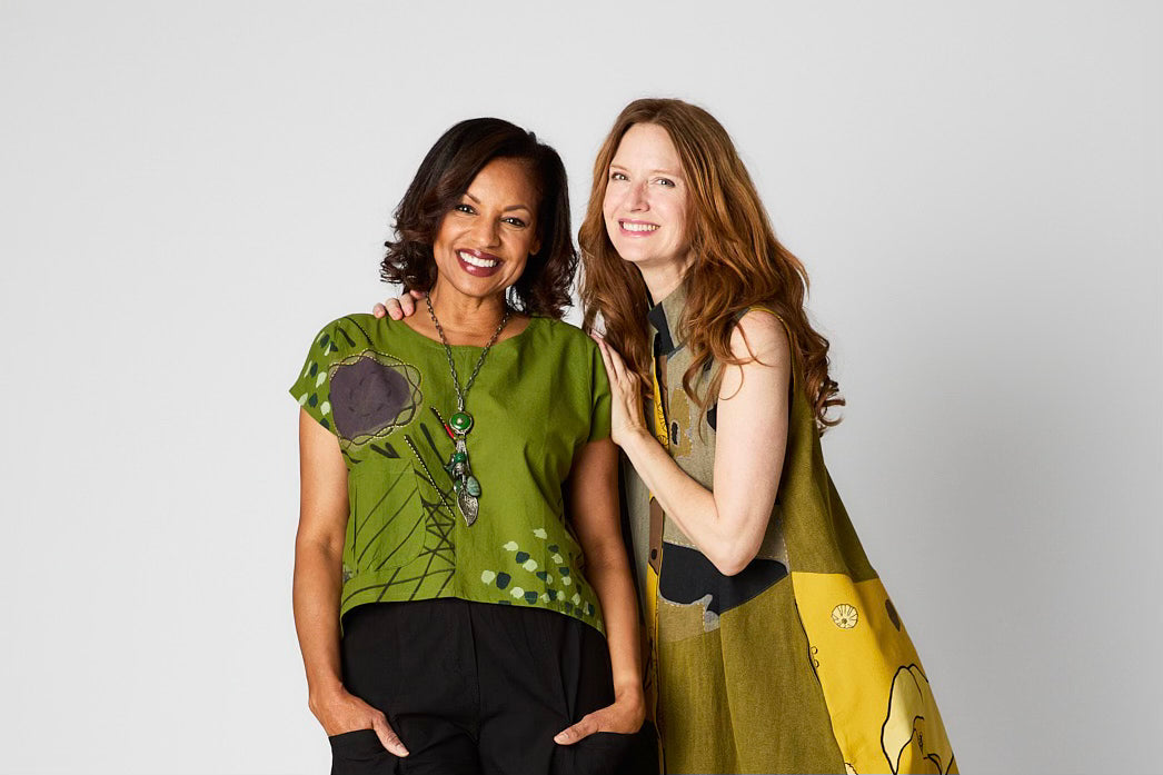 Two women against a white background wearing natural fabric clothing in vibrant colors