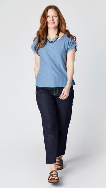 Model wearing denim cotton-linen jersey top with cropped sleeves, boatneck, and boxy silhouette with cropped dark wash wide-leg jeans and brown sandals.