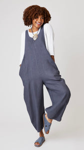 Model wearing "iron" linen overall jumpsuit with wide cropped dart leg, white 3/4 sleeve bias cut tee, and gray suede sandals.