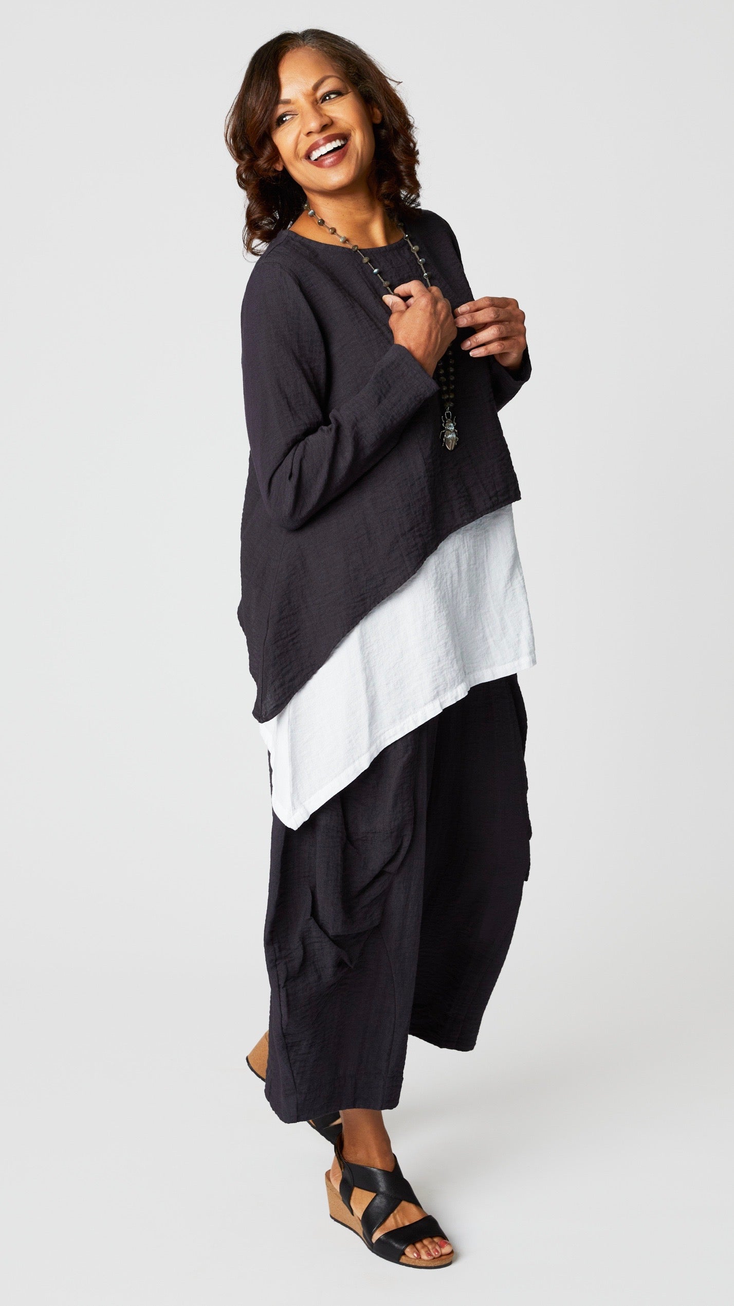 Model wearing black pearl long sleeve cropped top with A-line silhouette, chalk layer tank, and black pearl double pocket pant.