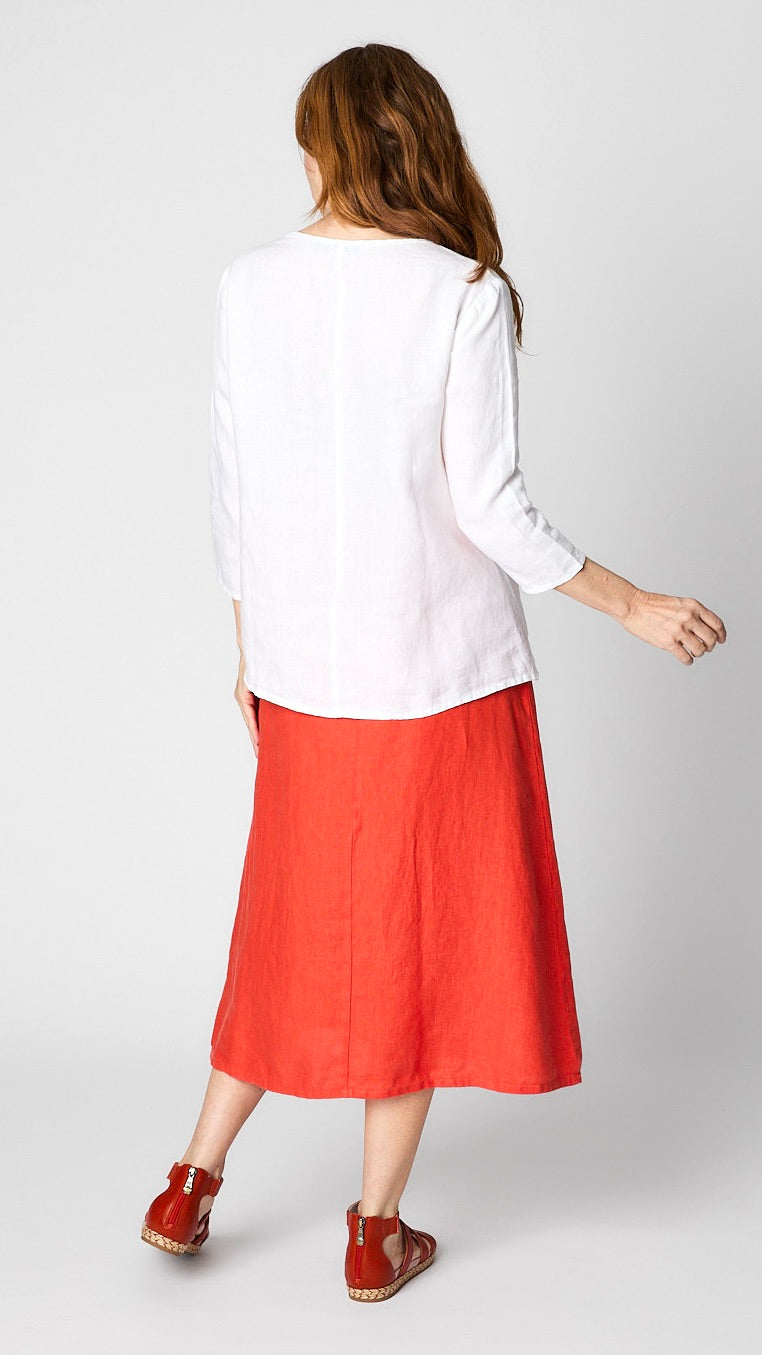 Rearview of model wearing A-line linen shirt and top shows rear vertical seam detail on both pieces. 