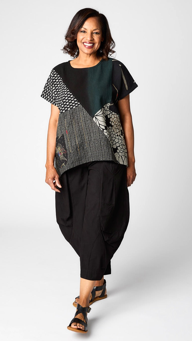 Model wearing black patchwork short sleeve top with black cropped double pocket pant in tencel cotton.