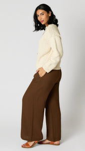 Model wearing natural cotton cropped crochet crew sweater, chocolate crinkle cotton palazzo pant, and brown leather sandals.