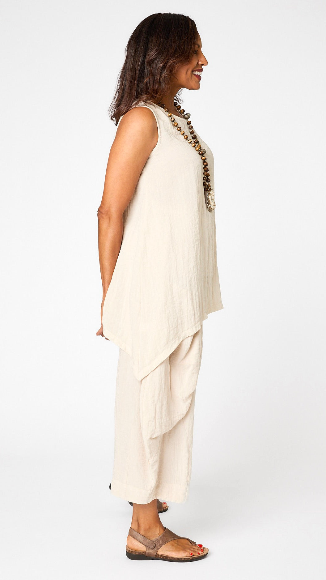Model wearing cloud long tunic tank with sweeping swing hemline, cloud double pocket pants, and brown sandals.