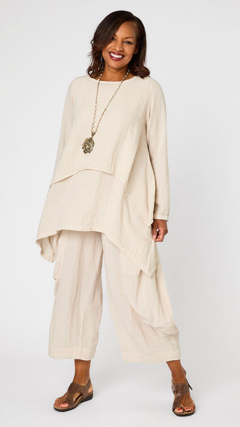 Model wearing cloud long sleeve cropped top with A-line silhouette, cloud layer tank, and cloud double pocket pant with brown leather sandal.