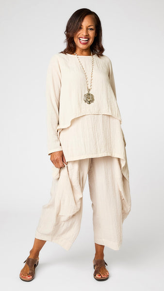 Model wearing cloud long sleeve cropped top with A-line silhouette, cloud layer tank, and cloud double pocket pant with brown leather sandal.