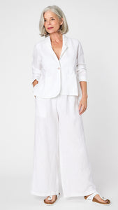 Model wearing white linen blazer over white, high waisted, wide leg linen pants with white sandals. 