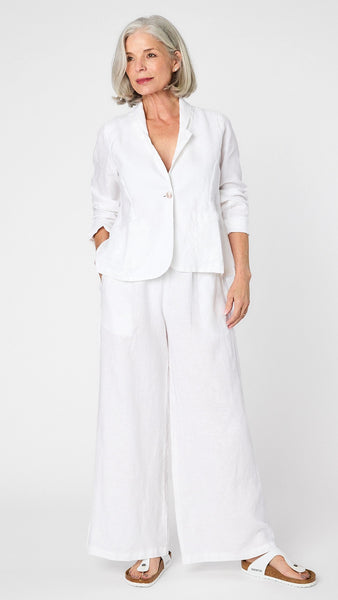 Model wearing white linen blazer over white, high waisted, wide leg linen pants with white sandals. 