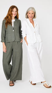 Two models pose together - one wears the linen blazer and wide leg linen pant set in white, and the other wears the set in  "clay" green-gray. 