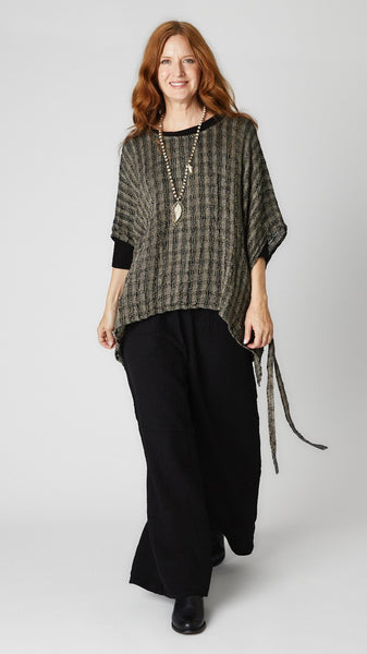 Model wearing black crinkle cotton palazzo pant, black loosely woven linen topper, and black leather boots.