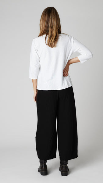 Model wearing white cotton-linen knit 3/4 sleeve bias cut tee, black cotton-linen knit cropped dart pant, and black leather boots.