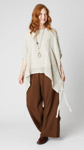 Model wearing loosely woven linen topper in "natural" with side ties, chocolate crinkle cotton palazzo pants, jasper pendant necklace, and brown leather boots.