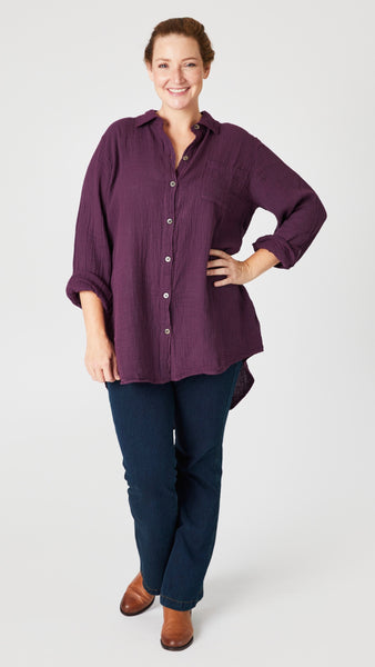 Model wearing eggplant double cotton button-up tunic/top, indigo denim trouser, and tan leather boots.