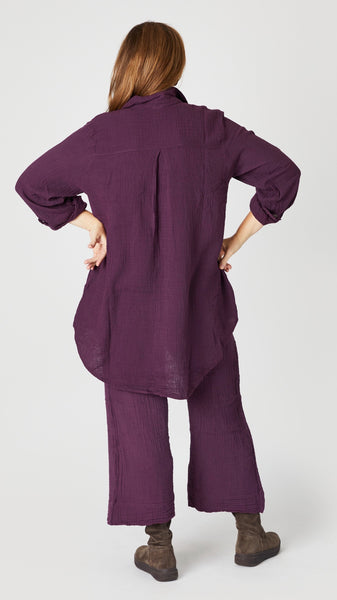 Rear view of eggplant double cotton button-up tunic shows flattering inverted box pleat detail.