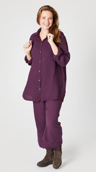 Model wearing eggplant double cotton button-up tunic/top, eggplant double cotton cropped wideleg pant, and knee-high suede boots.
