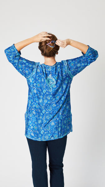 Rear view of model wearing blue embroidered silk tunic shows rear embroidered detail.