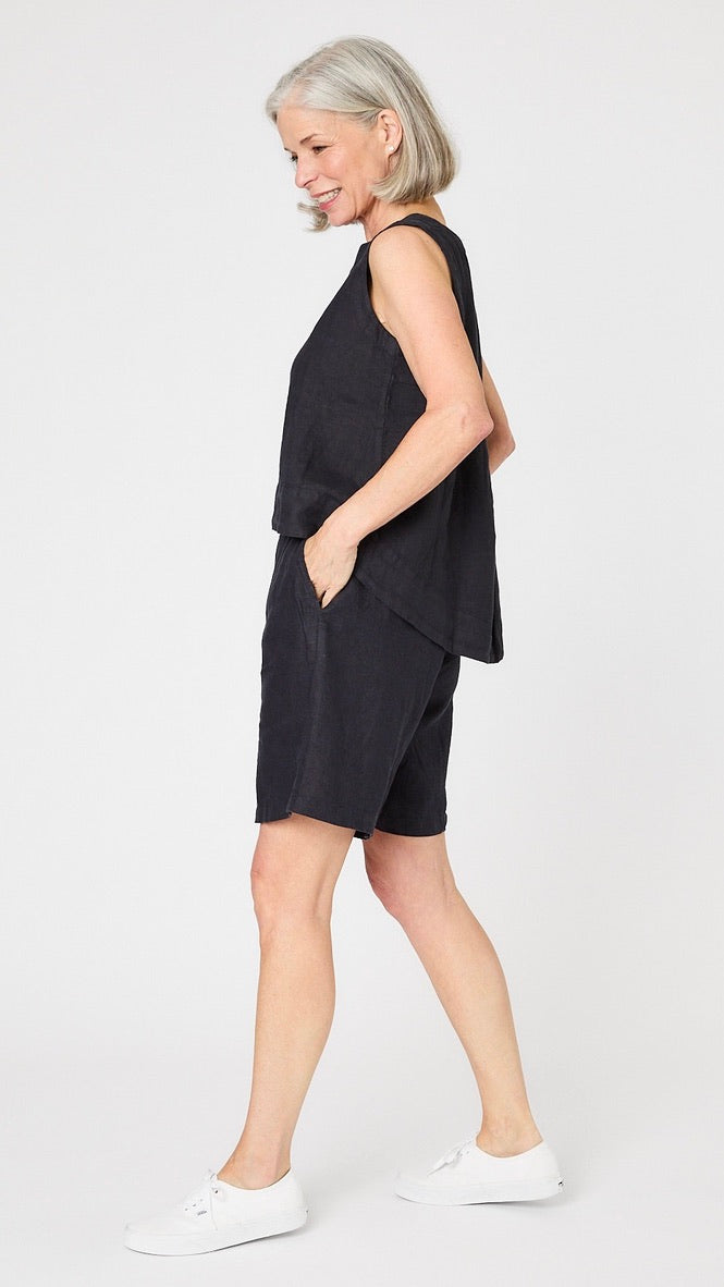 Model wearing ink linen sleeveless tank with hi-lo silhouette,  ink linen knee length shorts, and white sneakers.