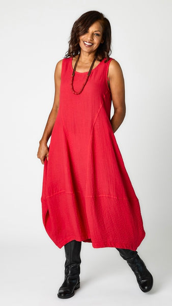 Model wearing "red zinc" sleeveless rayon dress with tulip hemline and round neck, single strand leather and red krobo bead necklace, and black leather boots. 