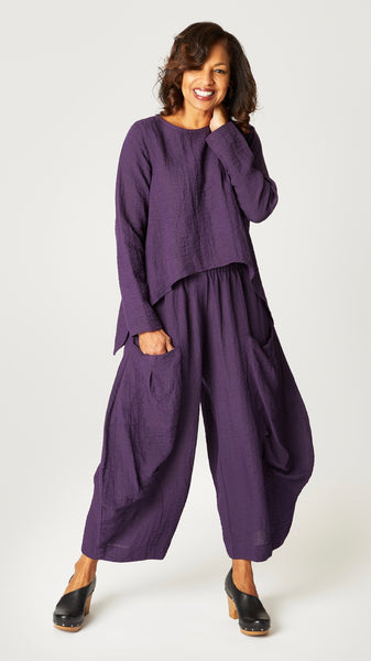 Model wearing eggplant long sleeve cropped top with A-line silhouette, eggplant double pocket pant.