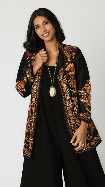 Model wearing bone Buddha necklace with brass beads, black rayon romper, and embroidered silk duster. 