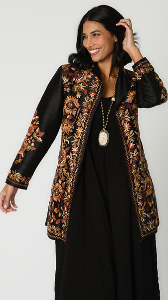 Model wearing bone Buddha necklace with brass beads, black rayon romper, and embroidered silk duster. 