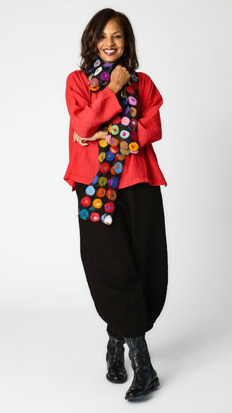 Model wearing relaxed fit rayon cowl neck top in "cinnabar" with silk and felted wool polka dot scarf, cropped rayon tucked hem  pant in black, and black leather boots.