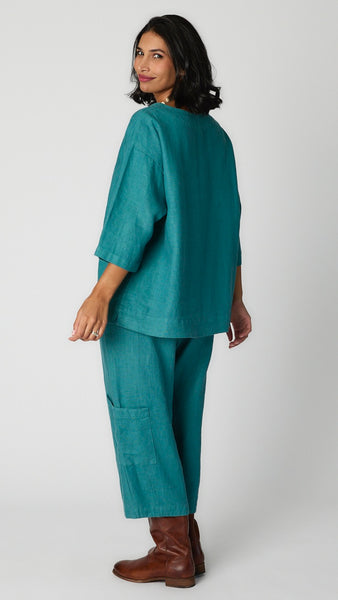 Model wearing iseo heavy linen top with scoop neck, drop shoulders, 3/4 sleeves, and wide seam, and iseo cropped pocket pant with brown leather boots. 