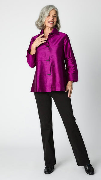 Model wearing violet raw silk button-up blouse with black horn buttons and 3/4 sleeves, black wideleg trousers, and black leather heeled boot.  