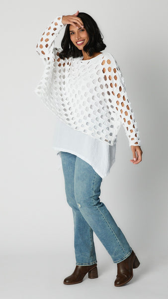 Model wearing white cotton handknit sweater overlay, white rayon tunic tank, and straight leg light wash jeans with brown leather stack heels.