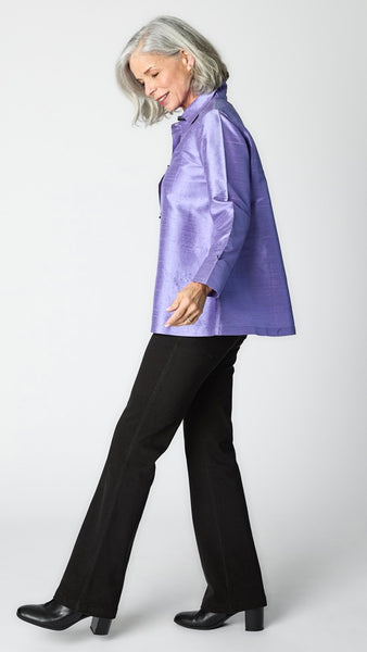 Model wearing periwinkle raw silk button-up blouse with black horn buttons and 3/4 sleeves, black wideleg trousers, and black leather heeled boot.  