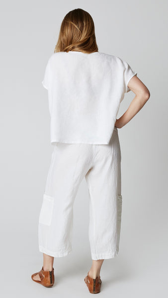 Rearview shows even hemline of white linen boxy top with cap sleeves.